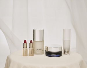 SENSAI Geschenke zum Muttertag auf einem Tisch mit goldener Tischdecke vor hellem, neutralem Hintergrund